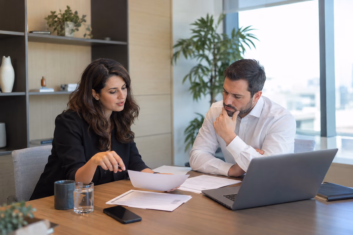 Two professionals reviewing a remuneration document in an office