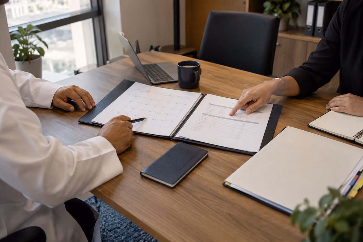 Two advisers comparing travel-date and company records for a tax residence application